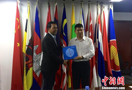 中國—東盟博覽會秘書處副秘書長黃平西（右）與柬埔寨新聞部新聞與傳播總司副總司長春占皮侖（左）互贈禮物。